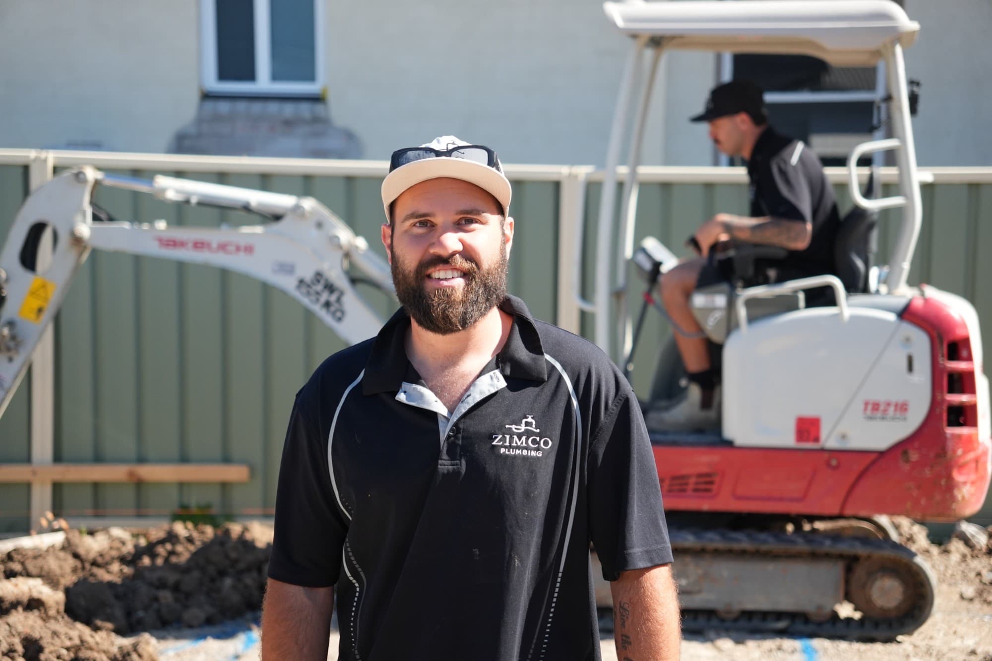Zimco leading hand Zac Taylor on site, with the mini excavator working behind him